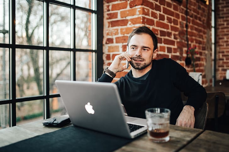 Empreendedor analisando documentos e notebook em ambiente de trabalho moderno
