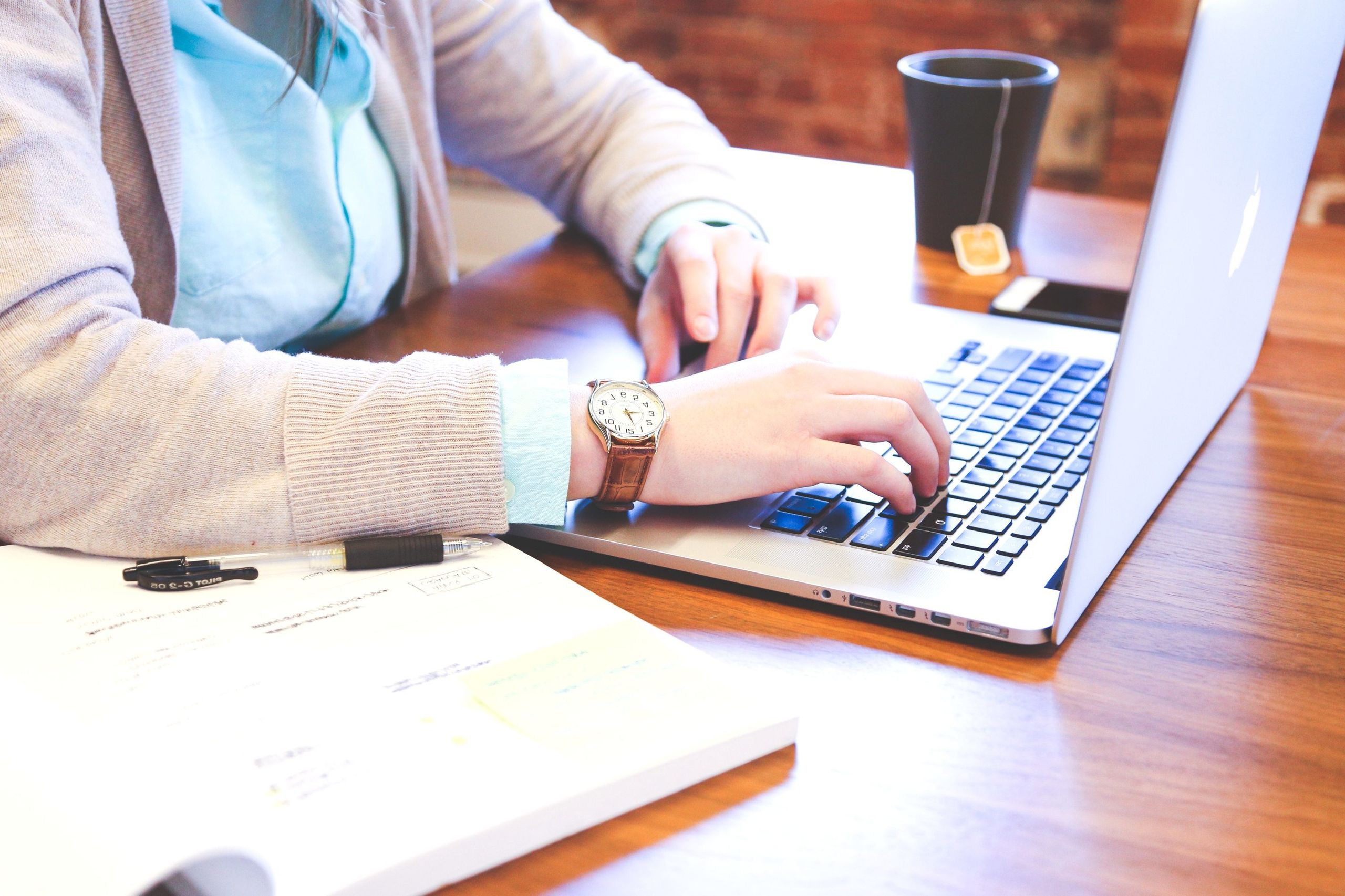 Empresária analisando documentos financeiros e notebook em ambiente de trabalho moderno